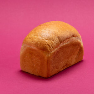 Ein Dinkelkasten-Brot auf einem pinken Hintergrund.