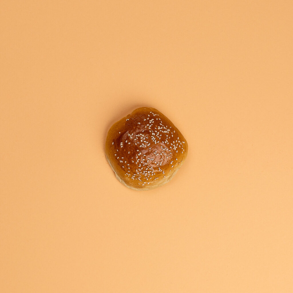 Burgerbrötchen vor beige-farbendem Hintergrund
